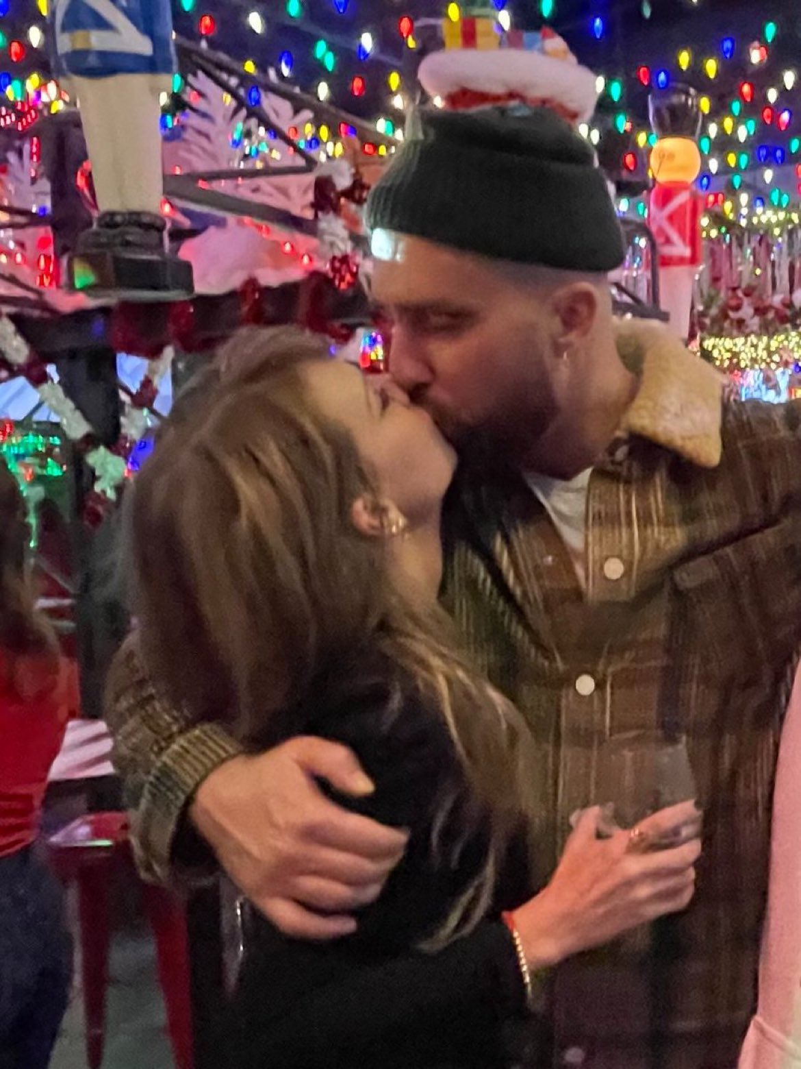 Taylor Swift and Travis Kelce kissing.